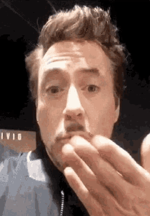 robert downey jr. is making a funny face with his hands .