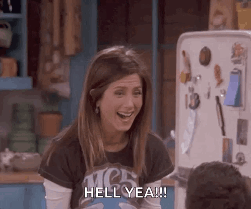 Rachel Green from Friends cheers in a kitchen with “HELL YEAH!” text.