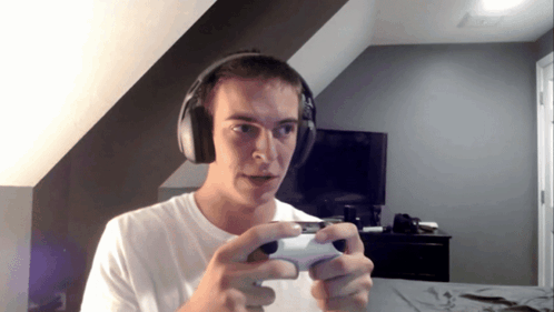 a man wearing headphones is holding a game controller