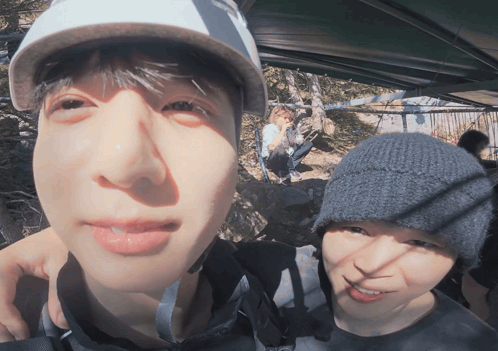Two bundled-up men take a distorted wide-angle outdoor selfie.