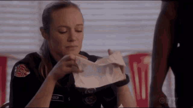 a woman is holding a piece of paper in her hands .