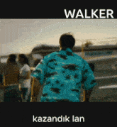 a man in a blue shirt is walking down the street