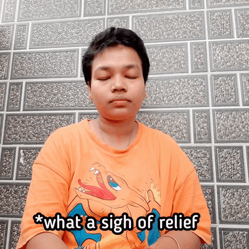 a man wearing an orange shirt with a pokemon on it says what a sigh of relief