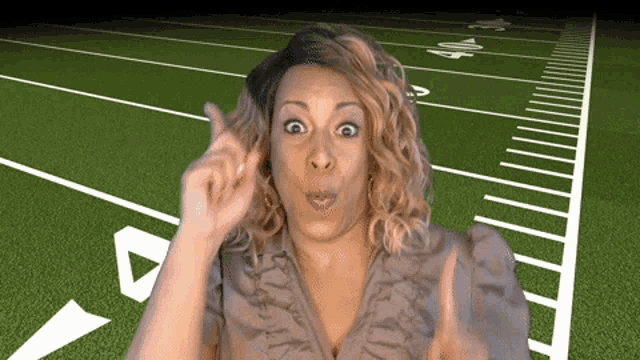 a woman stands in front of a football field with the number 40 on the sidelines