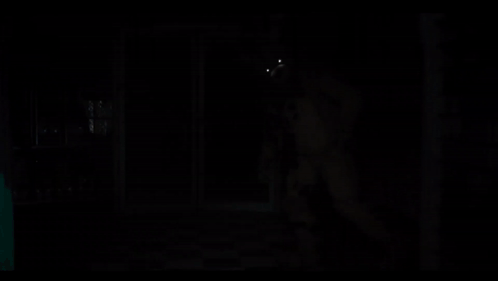 a teddy bear with glowing eyes is in the dark