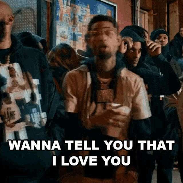 a man is standing in front of a crowd of people and saying `` wanna tell you that i love you ''