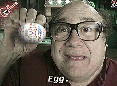 a man wearing glasses is holding an easter egg in his hand and says egg .