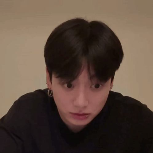 A man stares downward with wide, startled eyes.