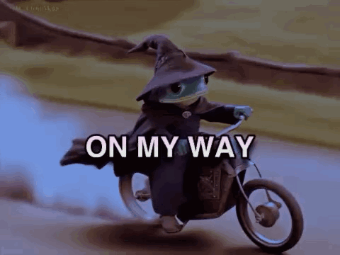 a lizard is riding a motorcycle with the words `` on my way '' written on it .