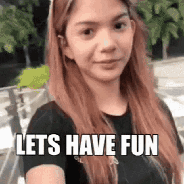a woman with long red hair is smiling and says `` let 's have fun '' .