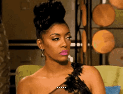 A woman with an elaborate updo looks aside with a disappointed expression.