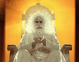 a man with white hair and a beard is sitting in a chair with his hands folded