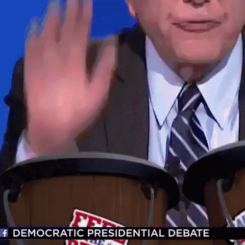 a man in a suit and tie is playing drums during a democratic presidential debate .