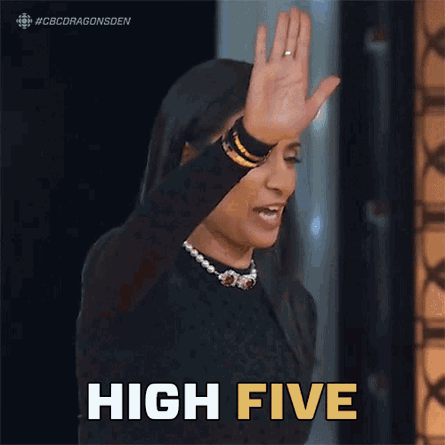 A woman in a dark outfit raises her hand beside the caption “HIGH FIVE.”
