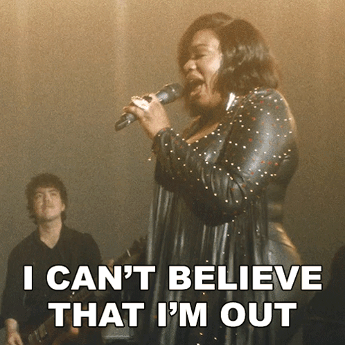 a woman singing into a microphone with the words i can 't believe that i 'm out behind her