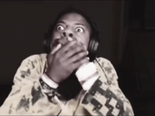 A person in headphones covers their mouth in sudden fright.