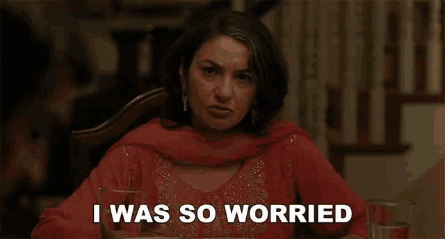 a woman sitting at a table with a glass of water and the words i was so worried behind her