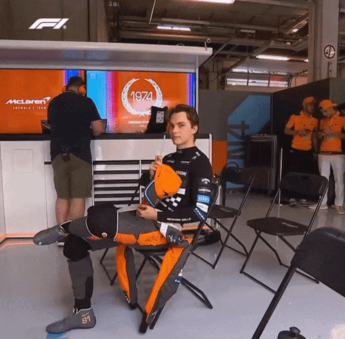 a man is sitting in front of a mclaren sign