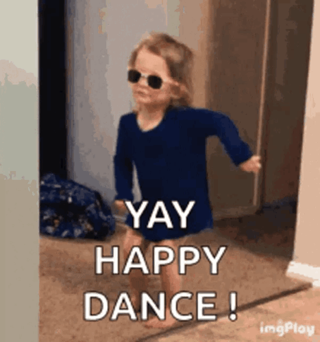 A toddler in sunglasses dances with “YAY HAPPY DANCE!”