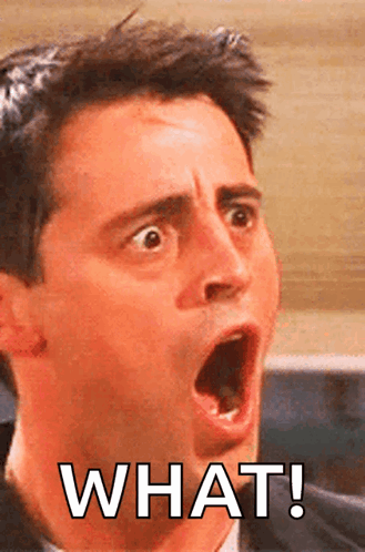 Joey Tribbiani stares with wide eyes and an open mouth above “WHAT!”