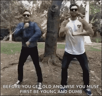two men are standing next to each other in a park .