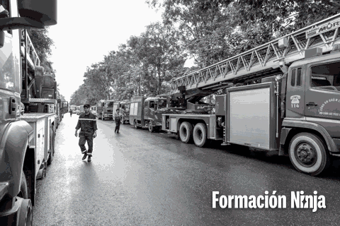 a black and white photo of a row of fire trucks with formacion ninja in the upper right corner
