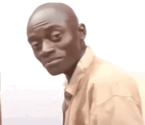 a man in a suit and tie is making a funny face while looking at the camera .