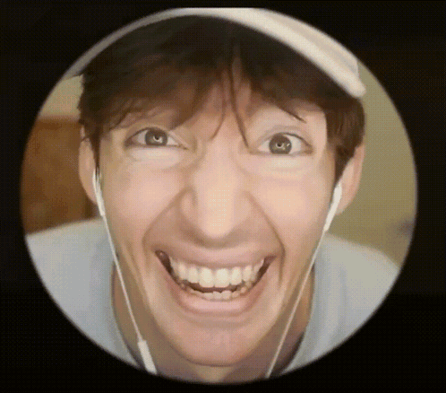 a man wearing ear buds and a hat is smiling