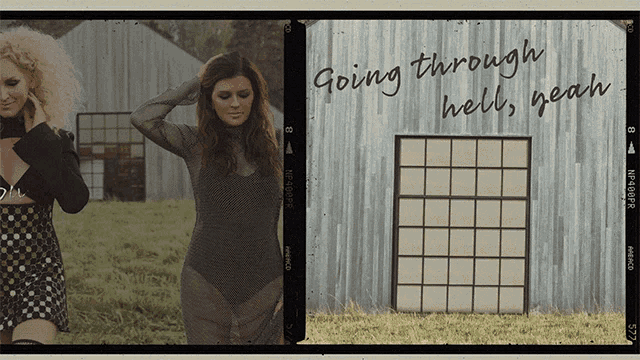 two women standing in front of a building with the words going through hell yeah written on it