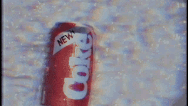 a red can of coca cola with a white label that says new