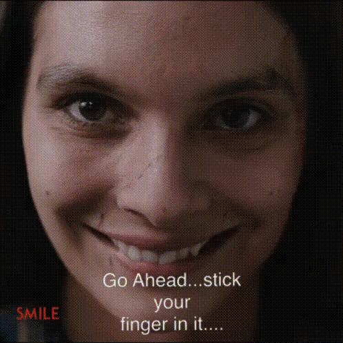 A close-up person smiles while text says “Go Ahead... stick your fingers in...”