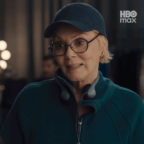 a woman wearing headphones and a baseball cap says excuse me