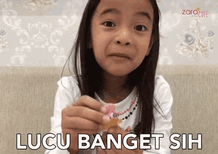 a little girl is holding something in her hand and the words lucu banget sih are written below her
