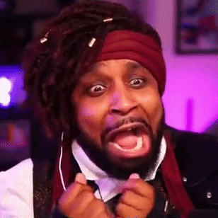 a man with dreadlocks and a beard is wearing a scarf around his head and making a funny face .
