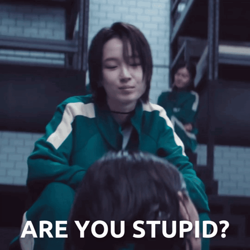 a woman in a green jacket is sitting next to another woman with the words " are you stupid " on the bottom