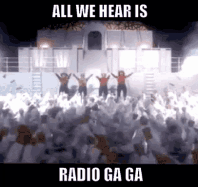 a crowd of people are gathered in front of a stage with the words " all we hear is radio ga ga "