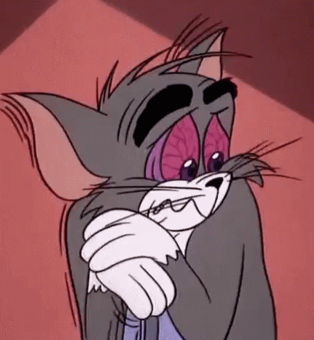 Tom from Tom and Jerry winces while holding his arm in pain.