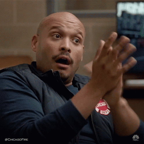 Man gives a dry, sarcastic clap while seated.