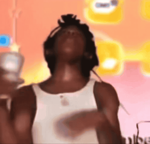 A man leans back in a colorful room in a cute-reaction meme.