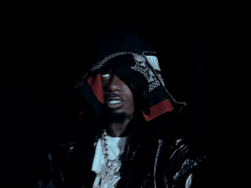 a man with a bandana on his head is wearing a hood