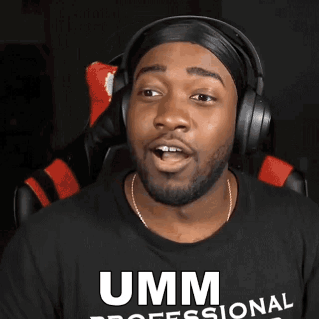 a man wearing headphones and a black shirt with the word umm on it