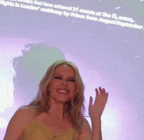 a woman stands in front of a screen that says ' london '