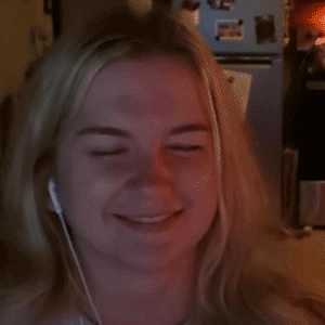 Blonde woman closes her eyes and smiles with embarrassed relief.