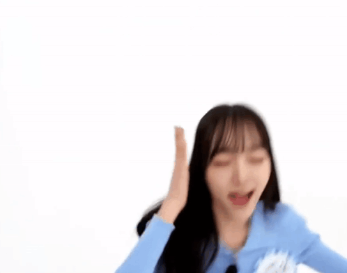 a blurry picture of a woman in a blue sweater dancing .