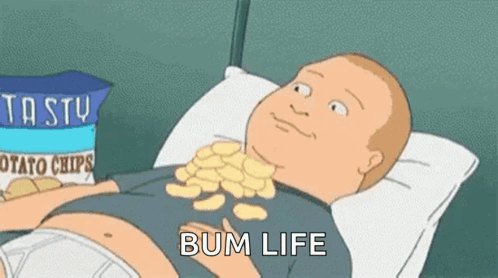 Bobby Hill reclines in bed eating potato chips with the caption “BUM LIFE.”