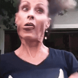 a woman in a blue shirt is making a funny face with her mouth open