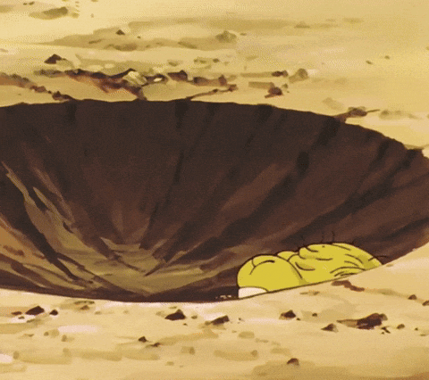 a yellow cartoon character is laying in a hole in the ground