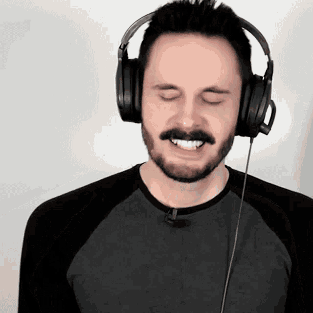 a man with a beard wearing headphones and smiling