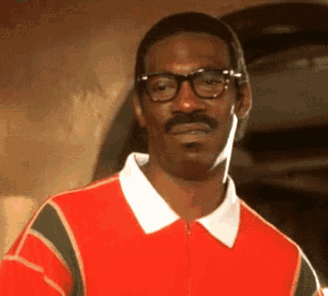 A man in glasses and a red polo stares forward in disgust.