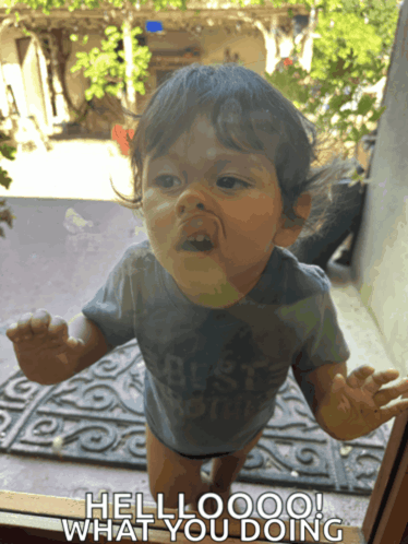 a baby standing in front of a window with the words hellooo what you doing on the bottom